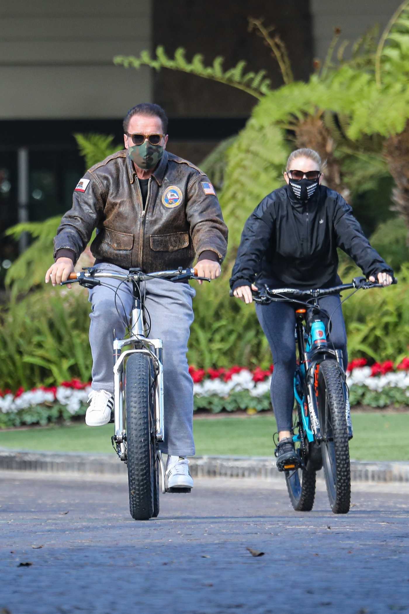 Arnold Schwarzenegger in a White Adidas Sneakers Does a Bike Ride Out with Heather Milligan in Santa Monica 11/08/2020