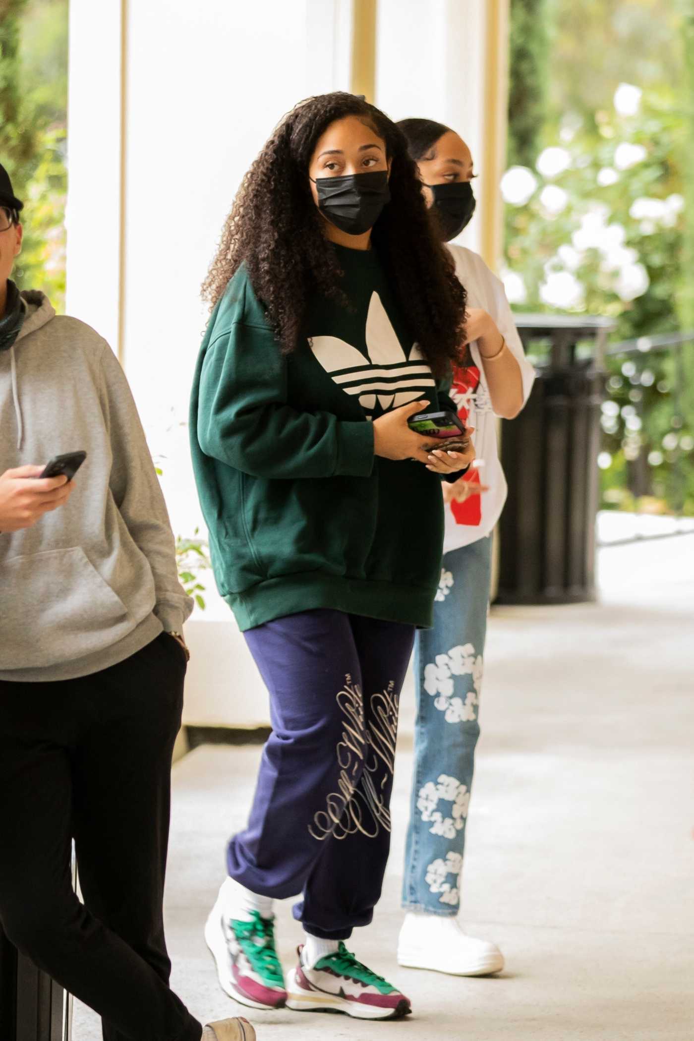 Jordyn Woods in a Green Adidas Sweatshirt Arrives at the Shibuya Sushi with Her Sister Jodie in Calabasas 05/16/2021