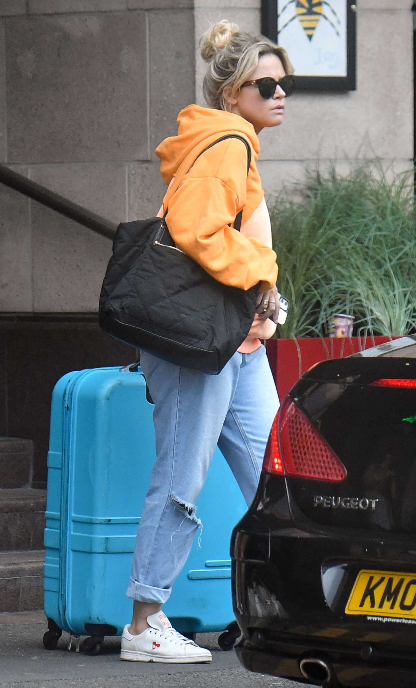Emily Atack in an Orange Hoodie Leaves Her Hotel in Manchester 08/15/2021