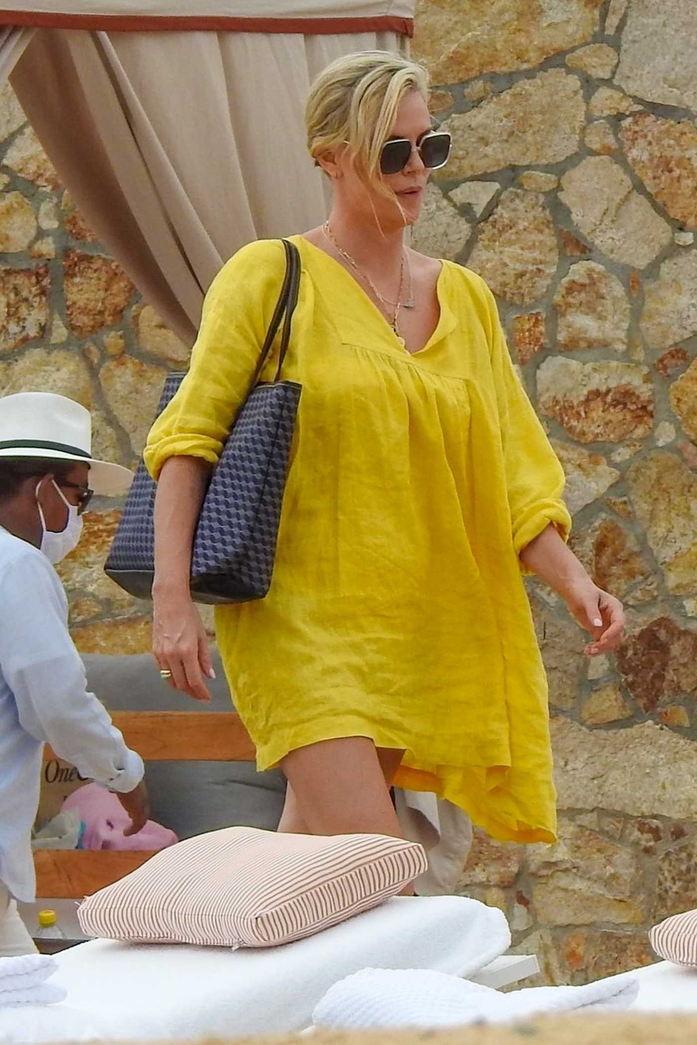 Charlize Theron in a Yellow Swimsuit Was Seen while Going for a Dip on the Beach in Cabo San Lucas 11/26/2021