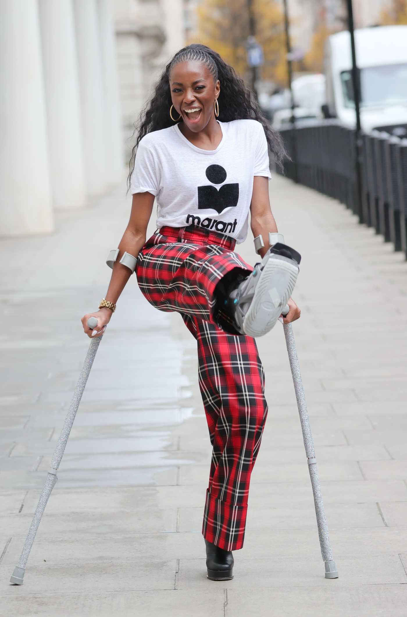 AJ Odudu in a Plaid Pants Heads Out from Morning Live TV on Crutches in London 12/20/2021