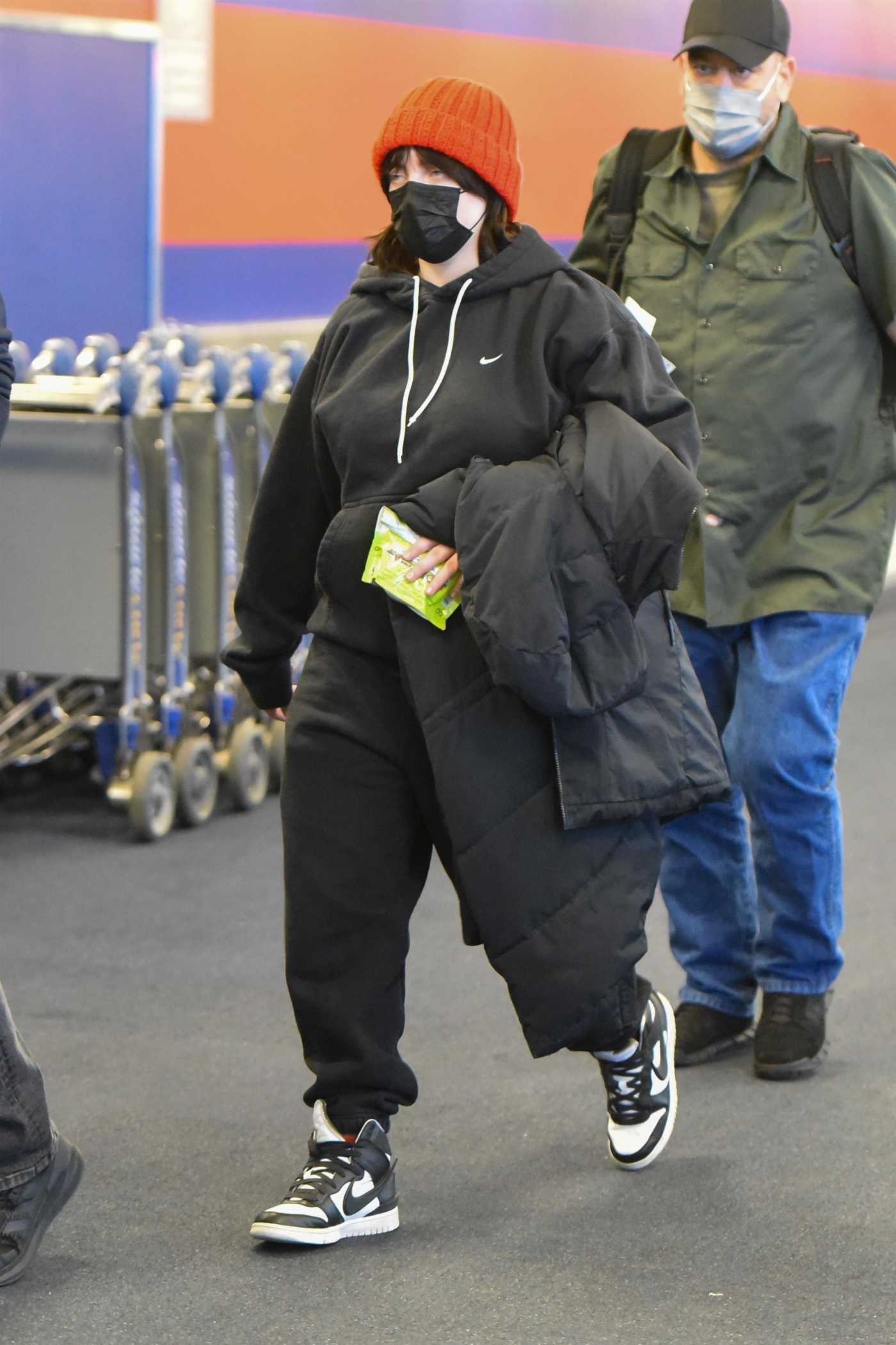 Billie Eilish in a Red Beanie Hat Arrives at JFK Airport in New York 12/13/2021