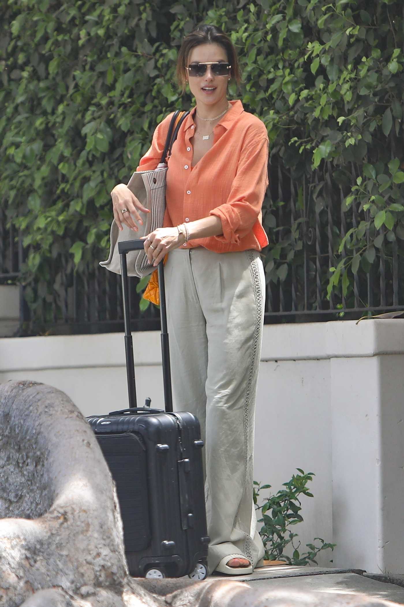 Alessandra Ambrosio in an Orange Shirt Makes Her Way to LAX Airport in Los Angeles 07/20/2022