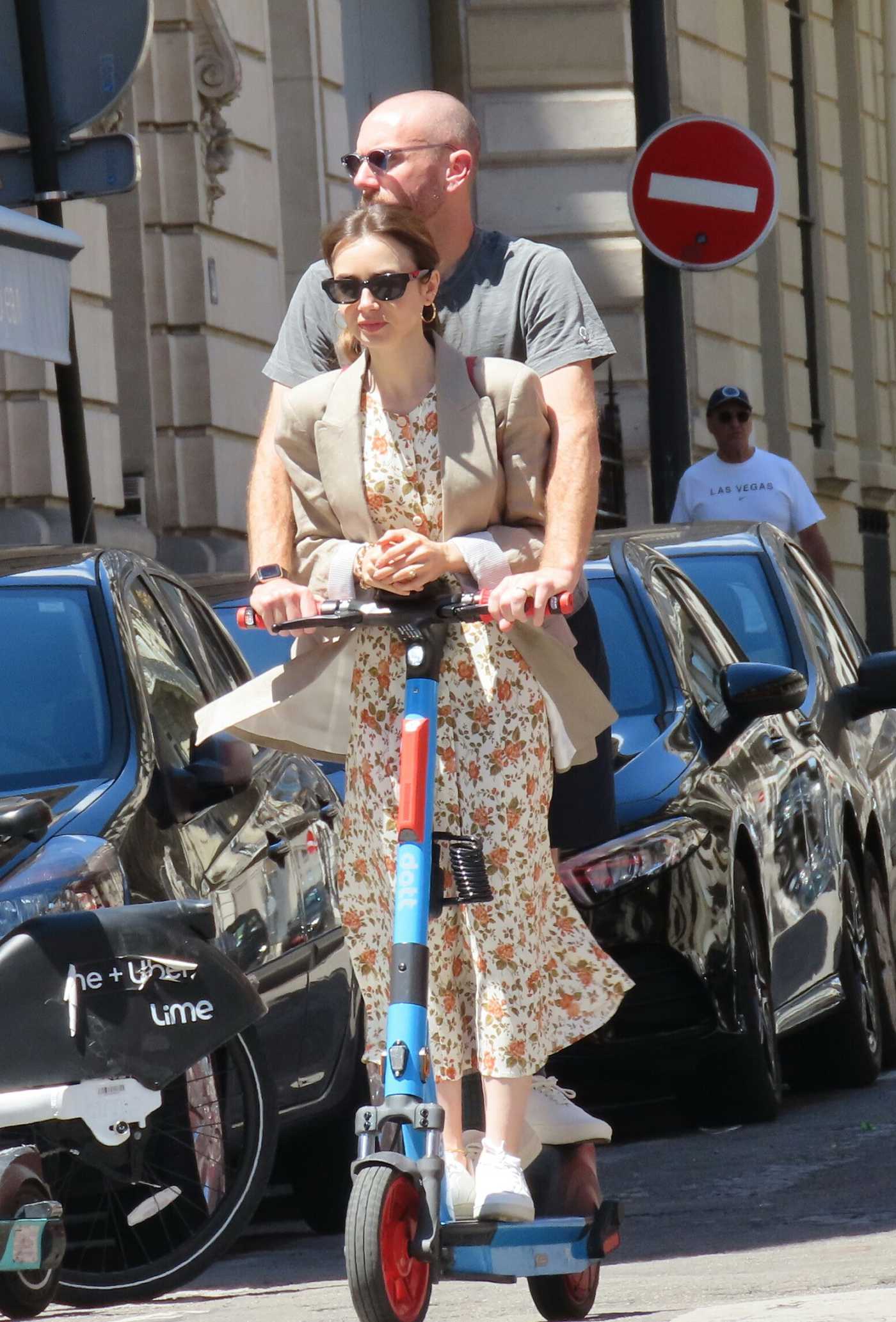 Lily Collins in a Beige Blazer and Hubby Charlie McDowell Seen Using an Electric Sharing Scooter in Paris 07/02/2022