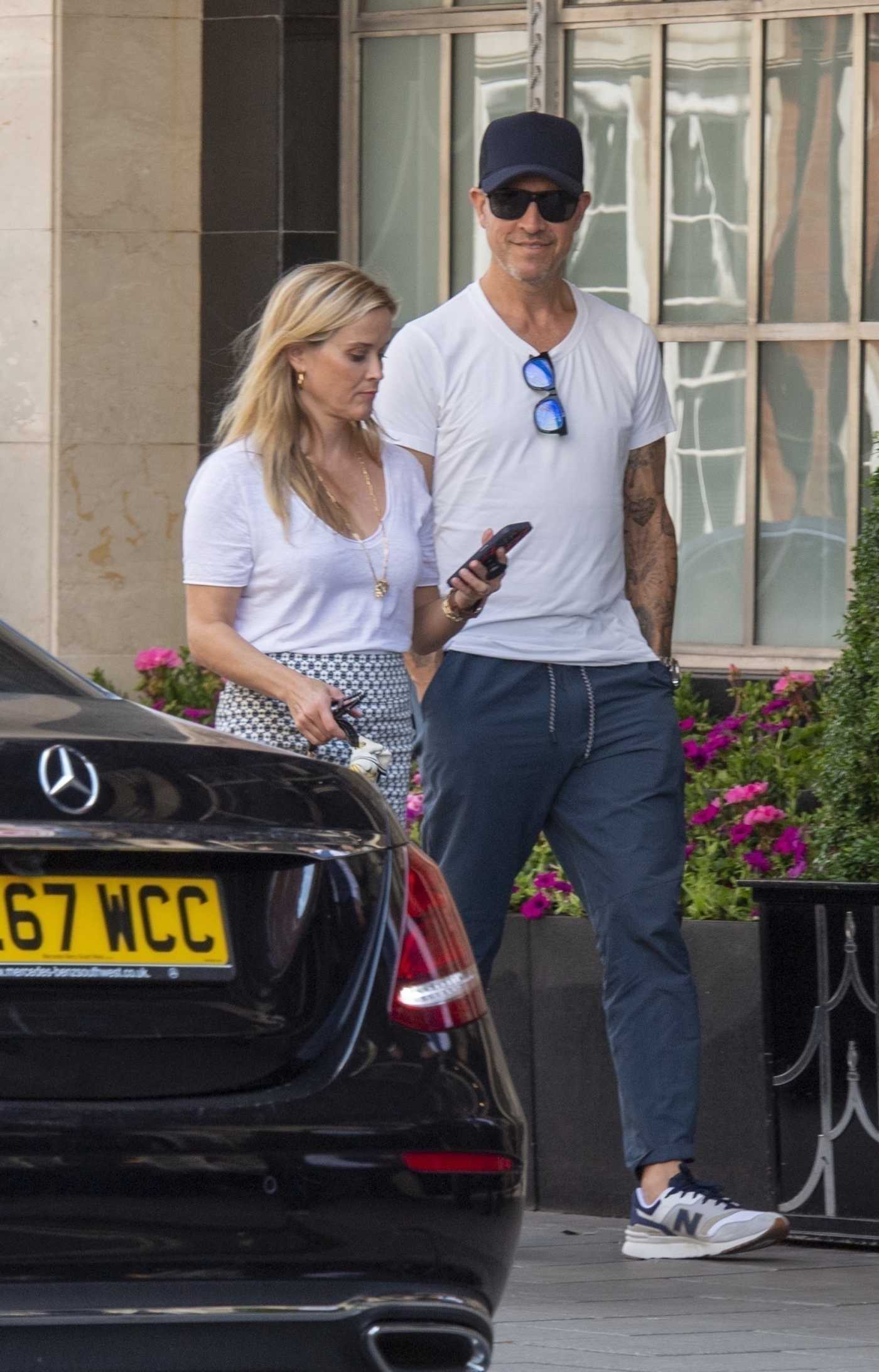 Reese Witherspoon in a White Tee Arrives with Her Husband Jim Toth at Claridge’s Hotel in London 07/13/2022