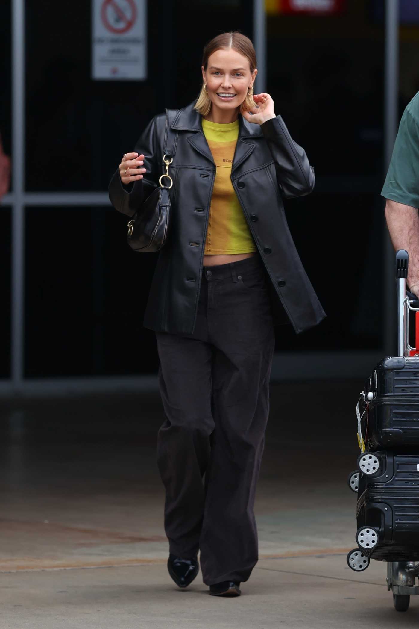 Lara Bingle in a Black Leather Blazer Arrives at Sydney International Airport in Sydney 09/25/2022