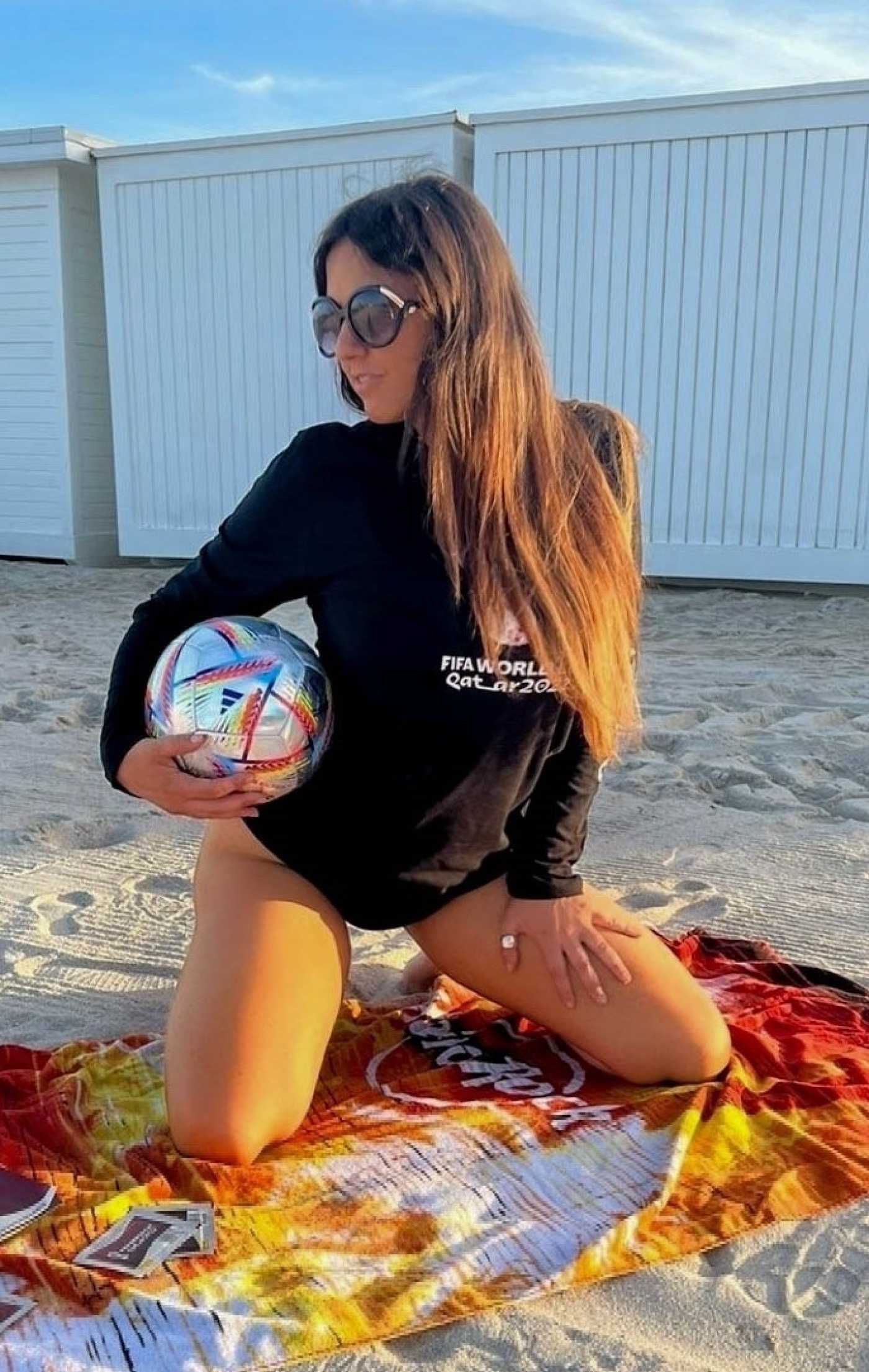 Claudia Romani in a Black World Cup Long Sleeve Shirt Was Seen on the Beach in Miami 11/27/2022