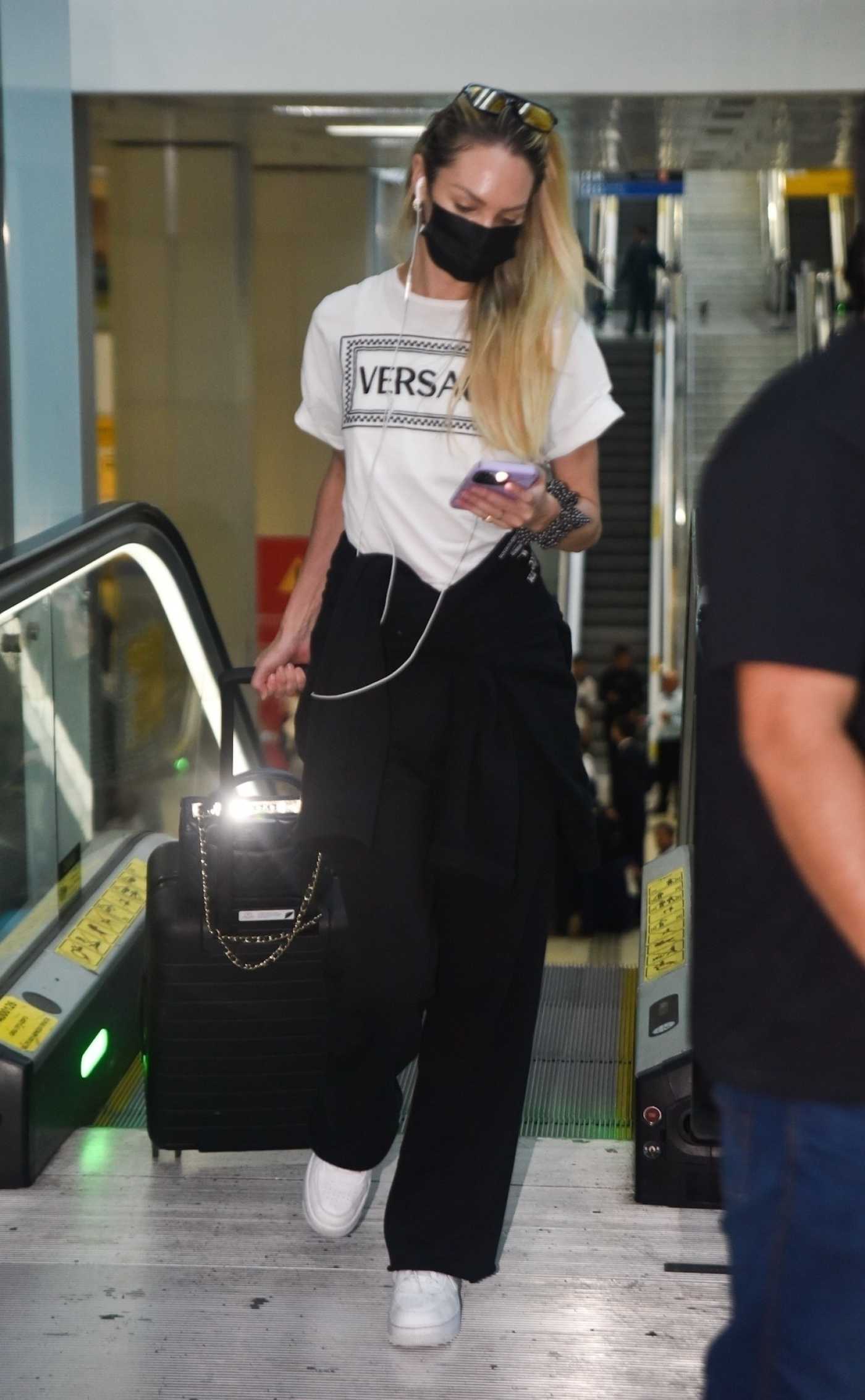 Candice Swanepoel in a White Versace Tee Touches Down at Guarulhos Airport in Sao Paulo 02/07/2023
