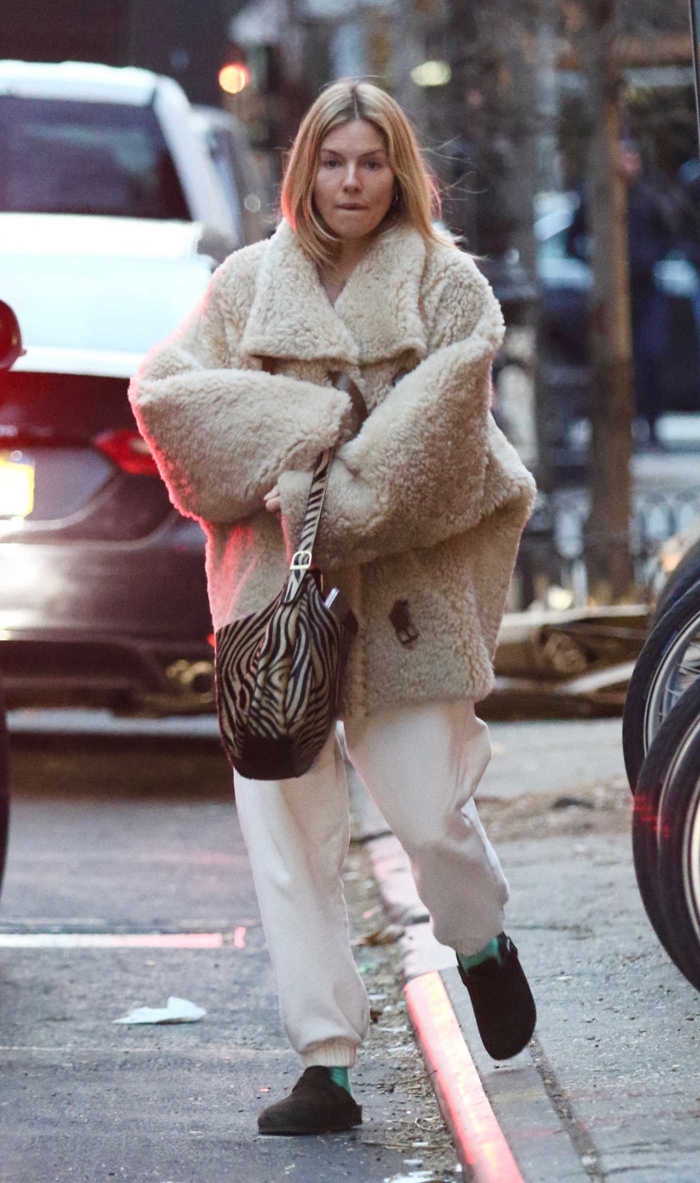 Sienna Miller in a White Sweatpants Leaves a Nail Salon in Manhattan’s SoHo Area in NYC 02/07/2023