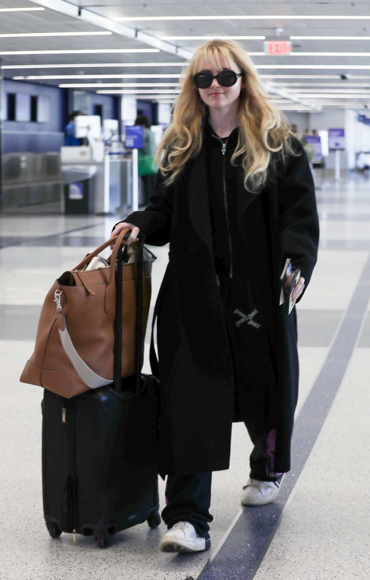Kathryn Newton in a Black Coat Catches a Flight at LAX Airport in Los Angeles 04/03/2023