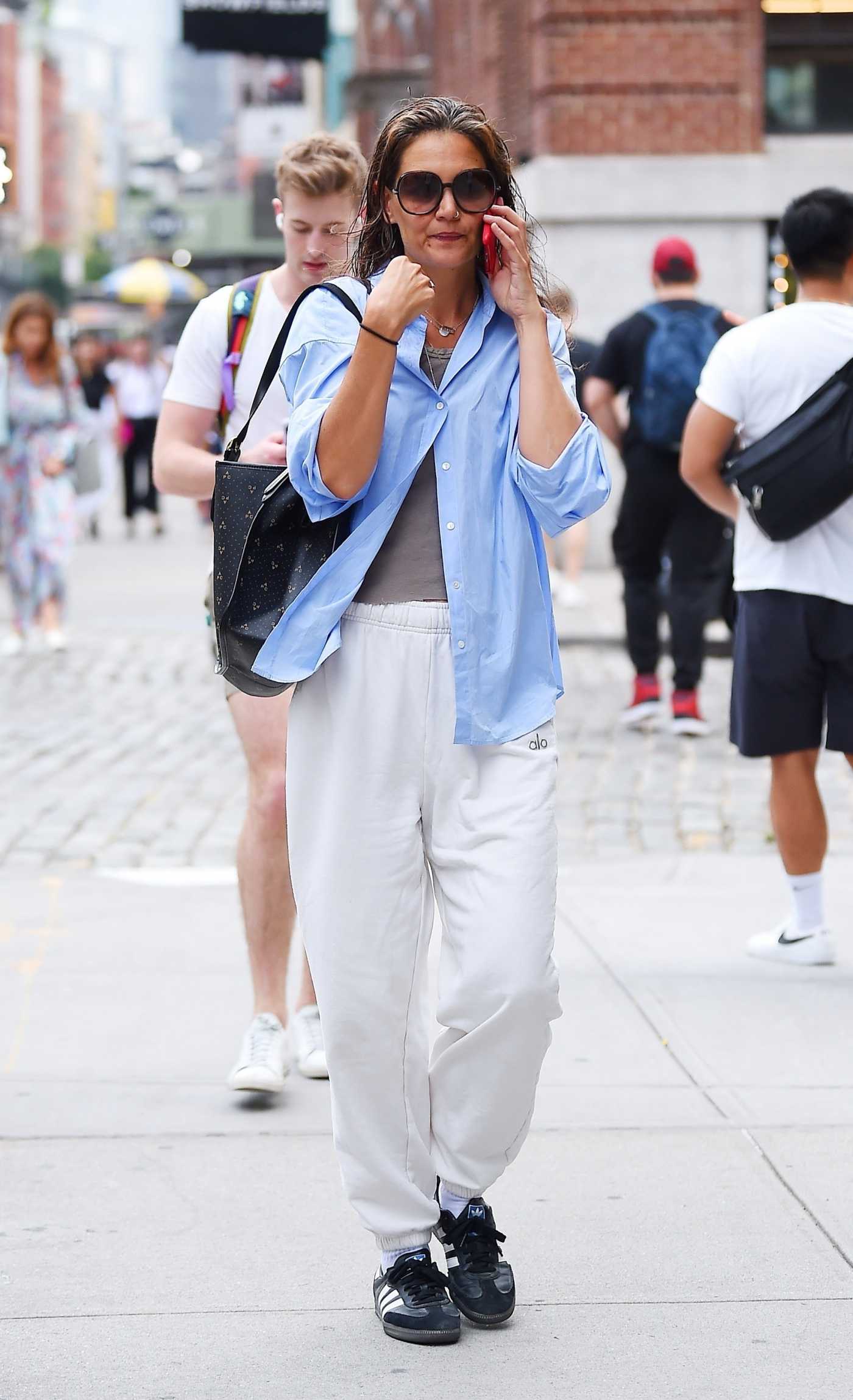 Katie Holmes in a White Sweatpants Chats on Her Phone During Her Big Apple Outing in New York 08/09/2023