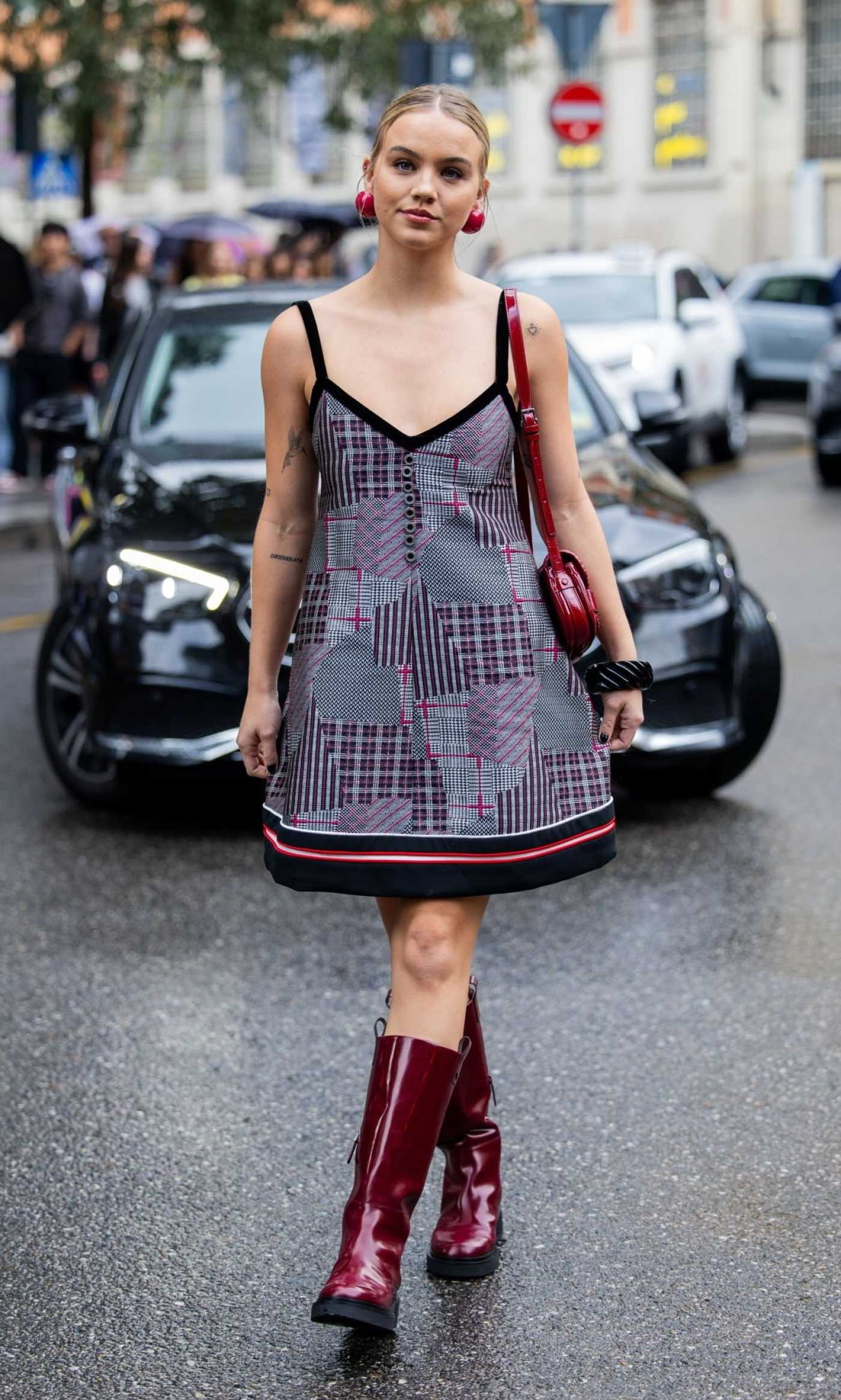 Emma Brooks McAllister in a Burgundy Knee-Length Boots Arrives at the Emporio Armani Fashion Show During 2023 Milan Fashion Week in Milan 09/21/2023
