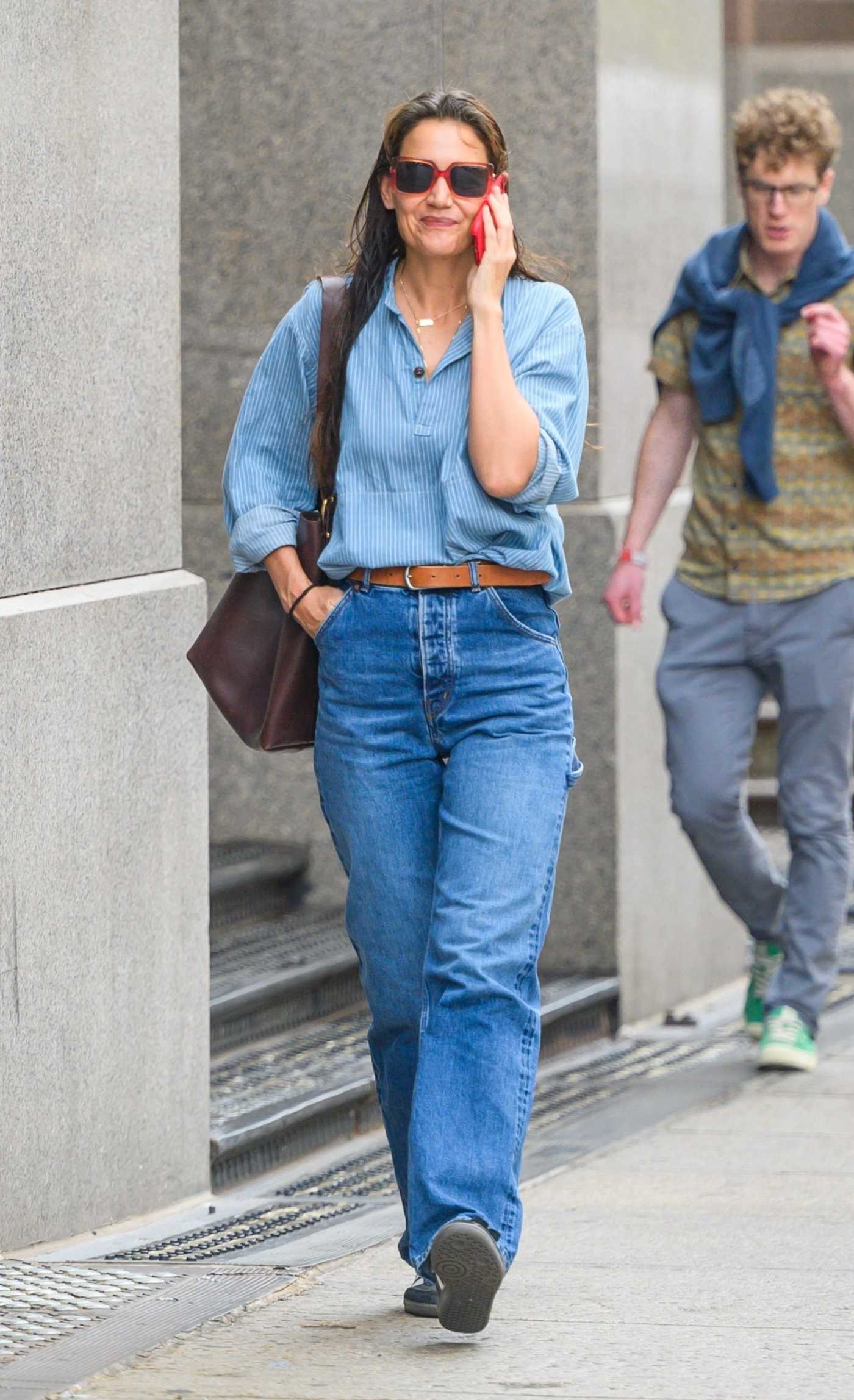 Katie Holmes in a Blue Jeans Chatting on the Phone During a Stroll Through the Streets of New York City 09/22/2023