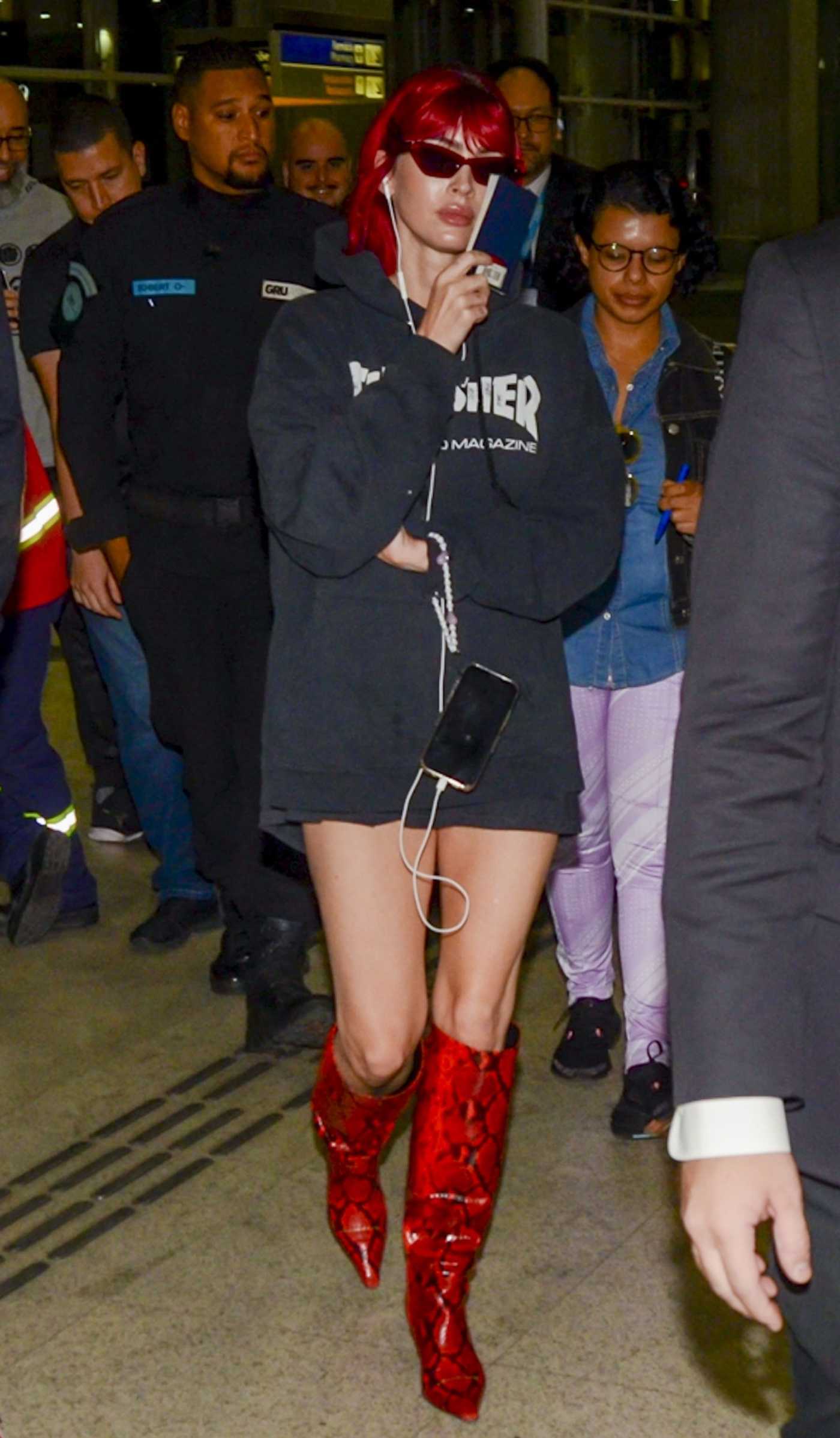 Megan Fox in a Red Snakeskin Knee-Length Boots Arrives at Guarulhos Airport in Sao Paulo 11/05/2023