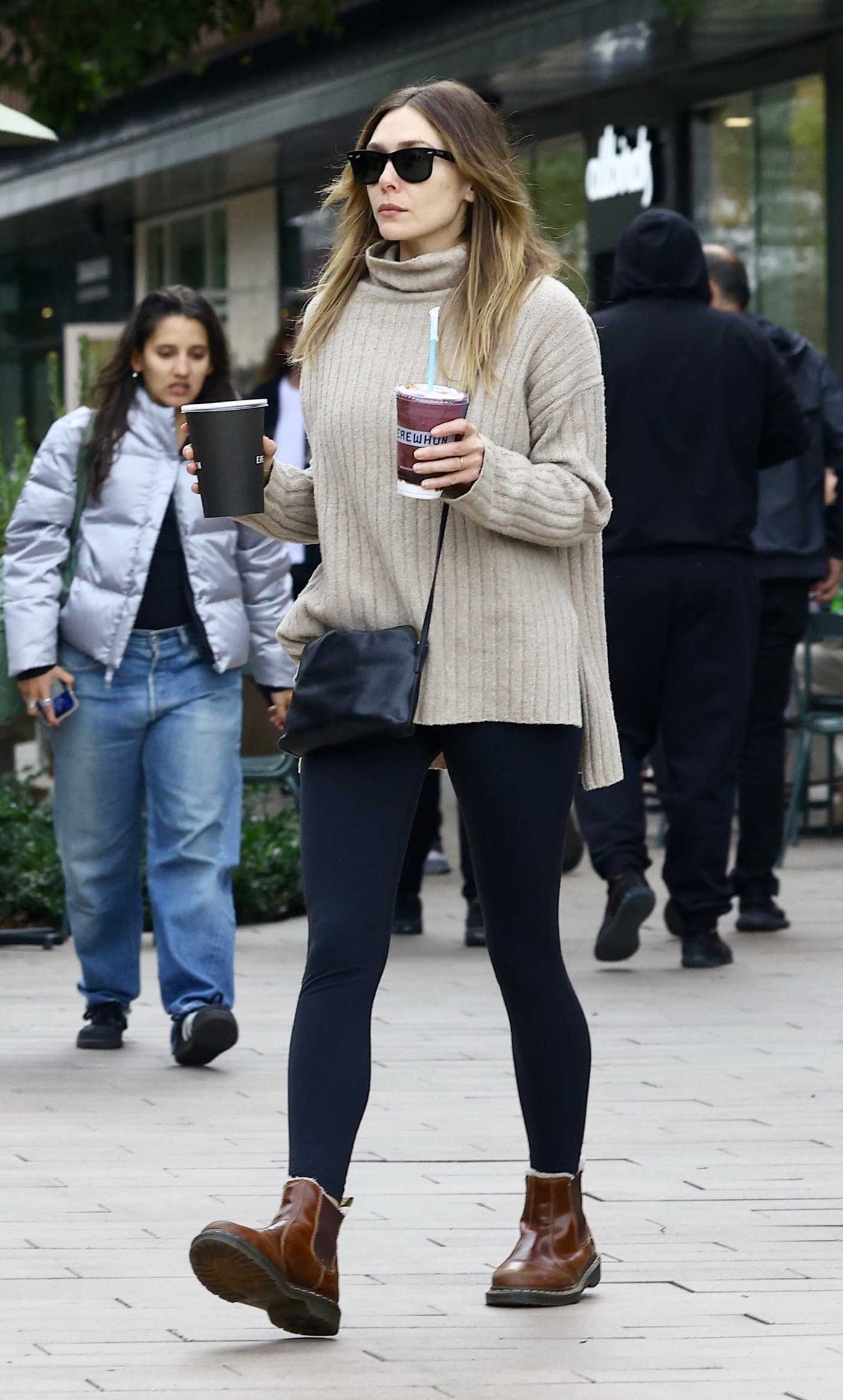 Elizabeth Olsen in a Beige Sweater Stops by Erewhon to Get a Smoothie in Studio City 11/29/2023