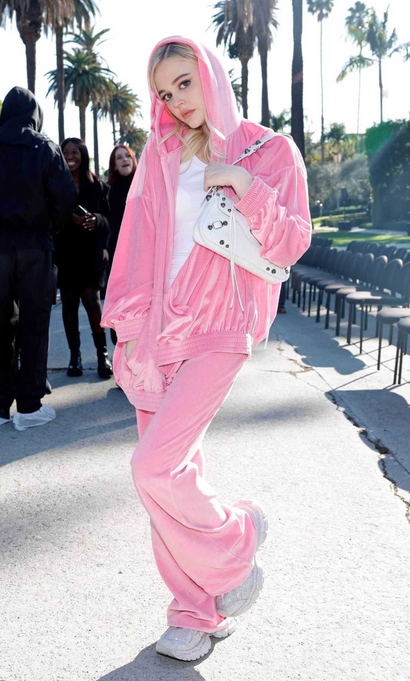 Emily Alyn Lind in a Pink Sweatsuit Arrives at the Balenciaga Fall 24 Show in Los Angeles 12/02/2023