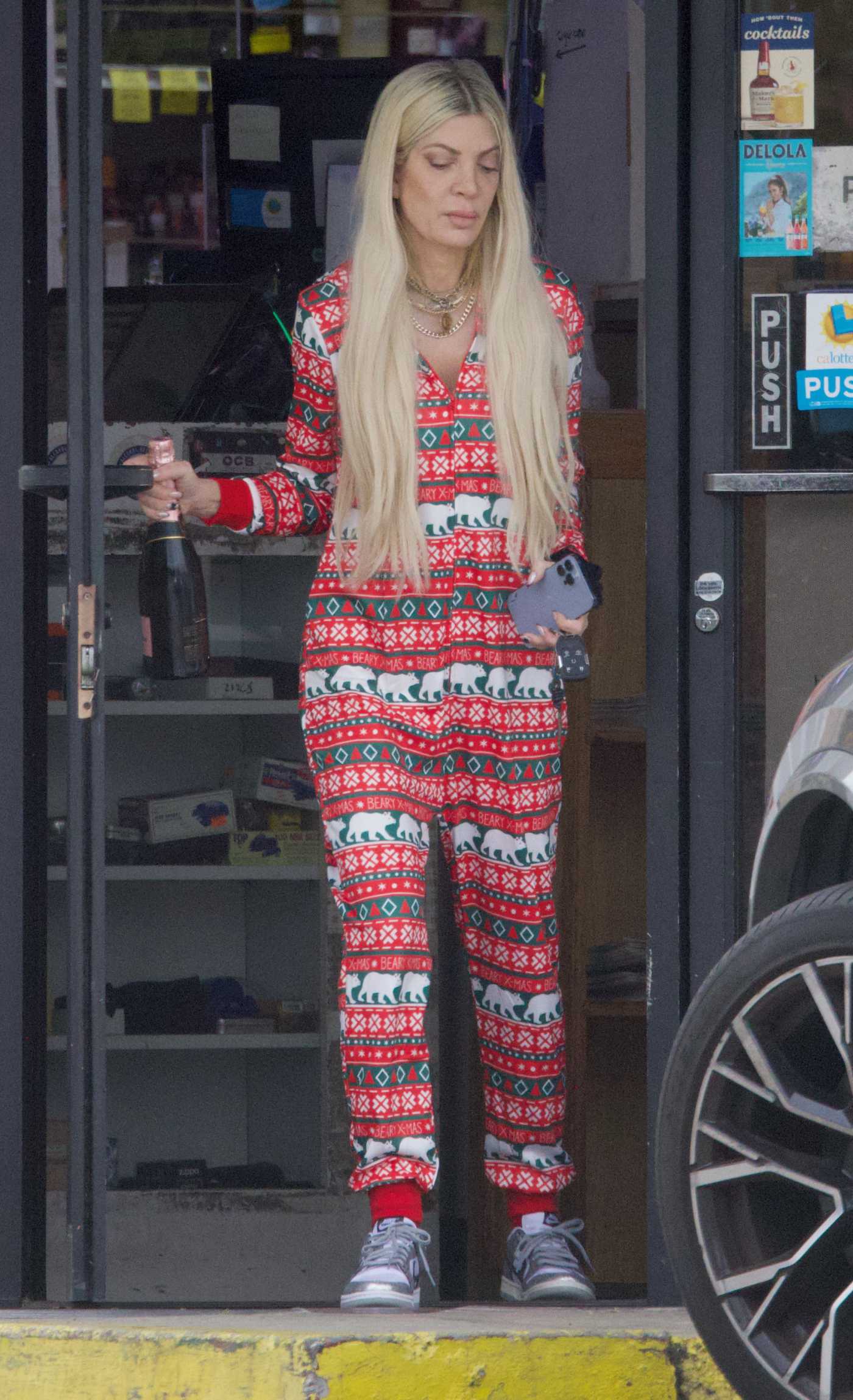 Tori Spelling in a Red Patterned Jumpsuit Visits a Liquor Store on New Year's Eve to buy Champagne in Los Angeles 12/31/2023