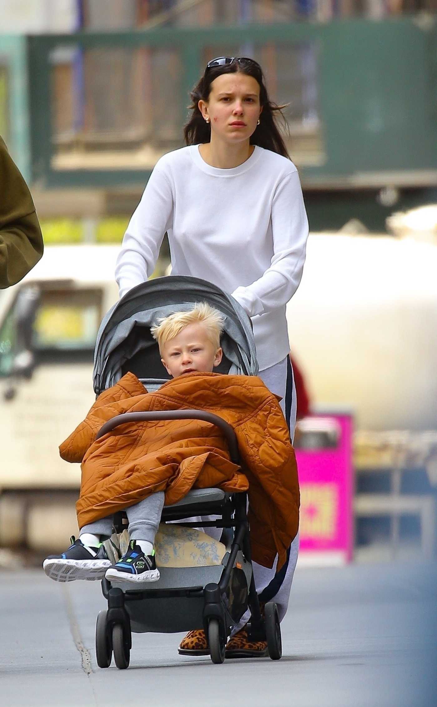 Millie Bobby Brown in a White Sweatshirt Spends a Babysitting Day Out with Jacob Bongiovi in New York City 04/17/2024