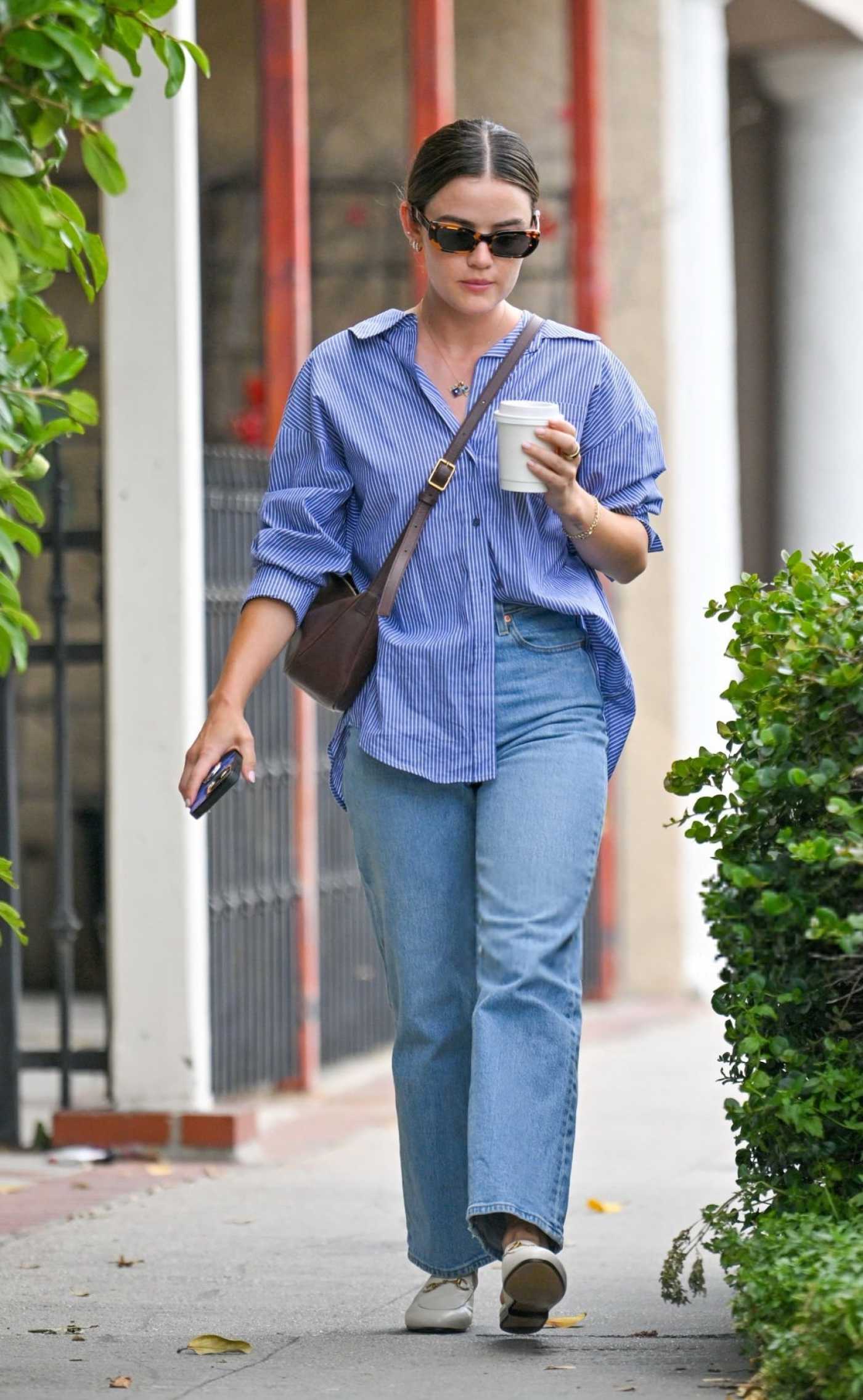 Lucy Hale in a Blue Jeans Picks Up a Cup of Coffee in Los Angeles 05/25/2024