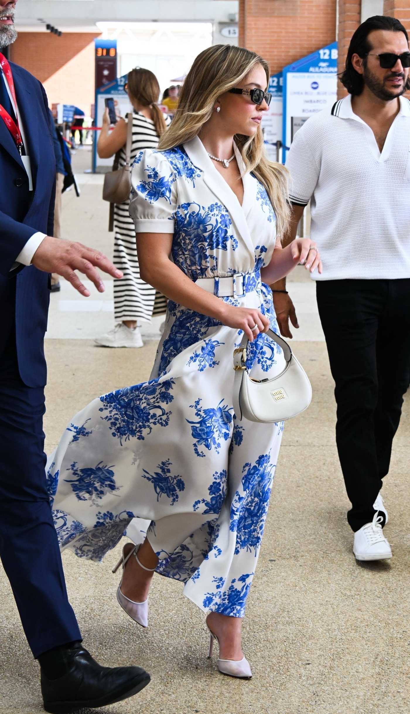 Sydney Sweeney in a White and Blue Floral Dress Arrives at Airport in Venice 08/31/2024