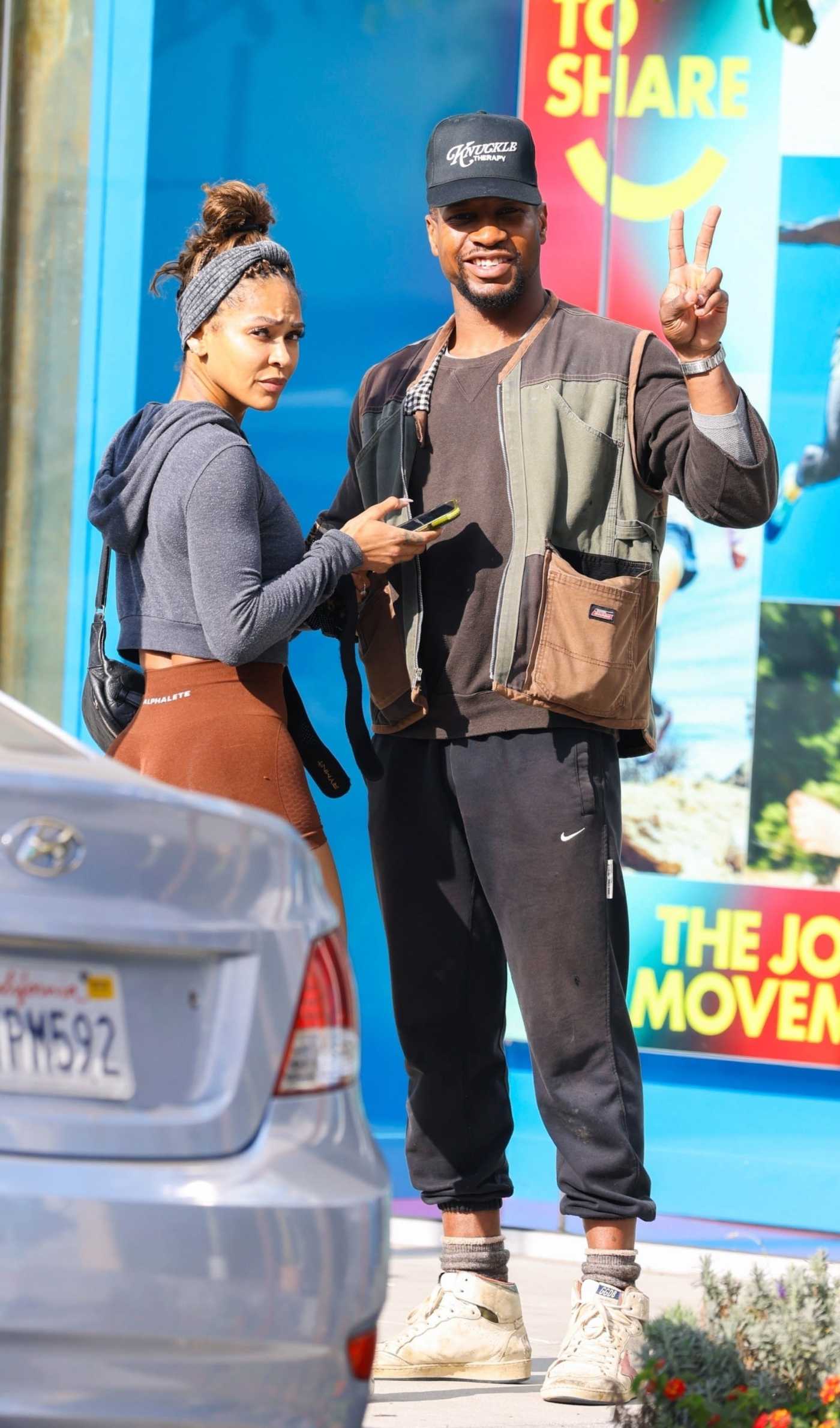 Meagan Good in an Orange Spandex Shorts Enjoys Some Last Minute Holiday Shopping with Jonathan Majors in West Hollywood 12/24/2024