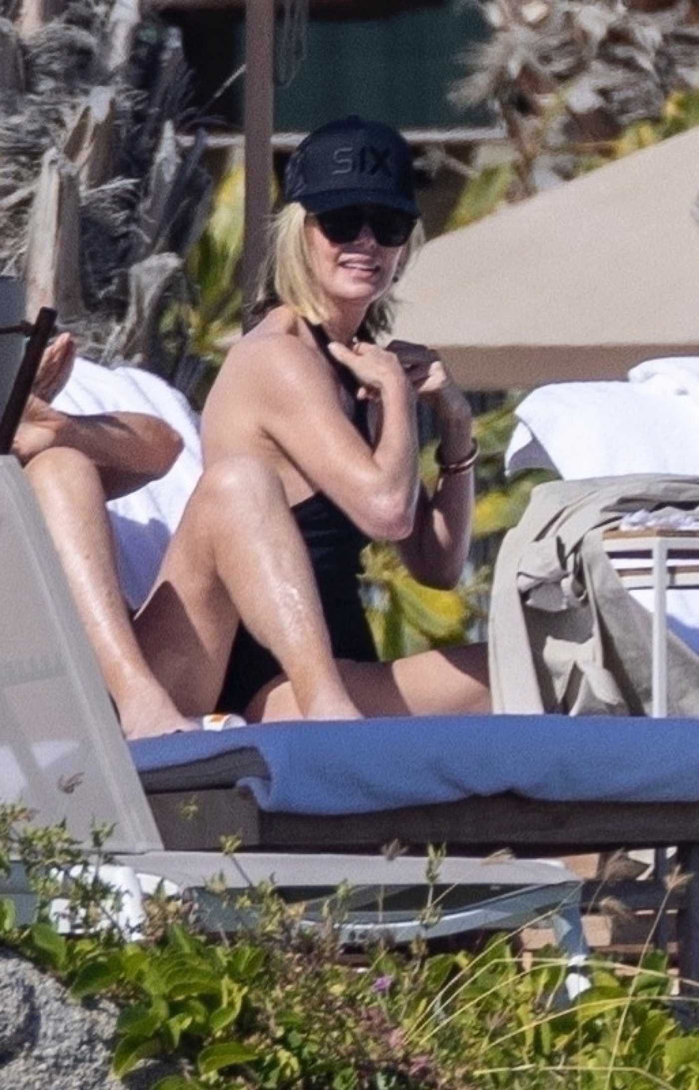 Charlize Theron in a Black Swimsuit by the Pool in Cabo San Lucas 12/30/2024