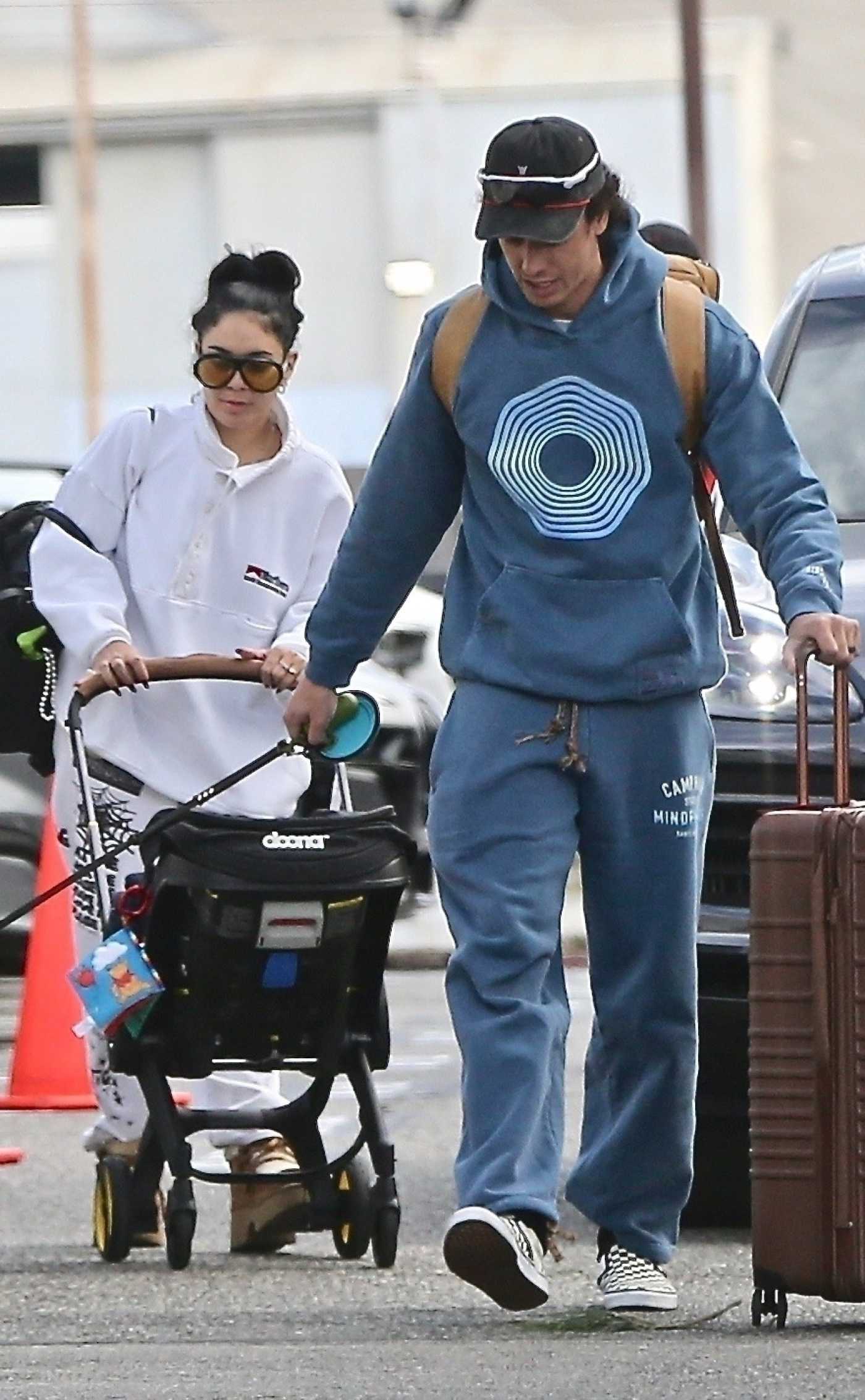 Vanessa Hudgens in a White Sweatsuit Arrives at Burbank Airport with Cole Tucker in Burbank 01/08/2025